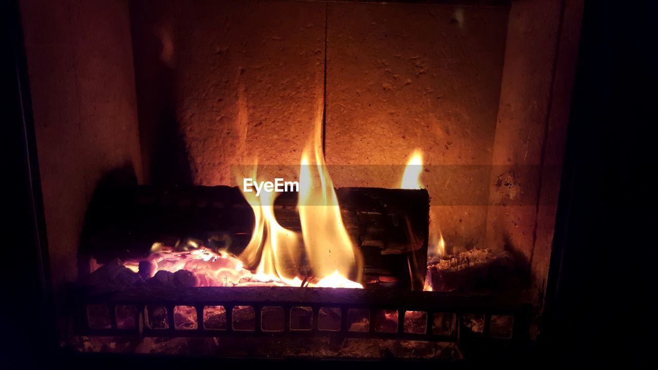 CLOSE-UP OF ILLUMINATED BURNING CANDLES IN ROOM