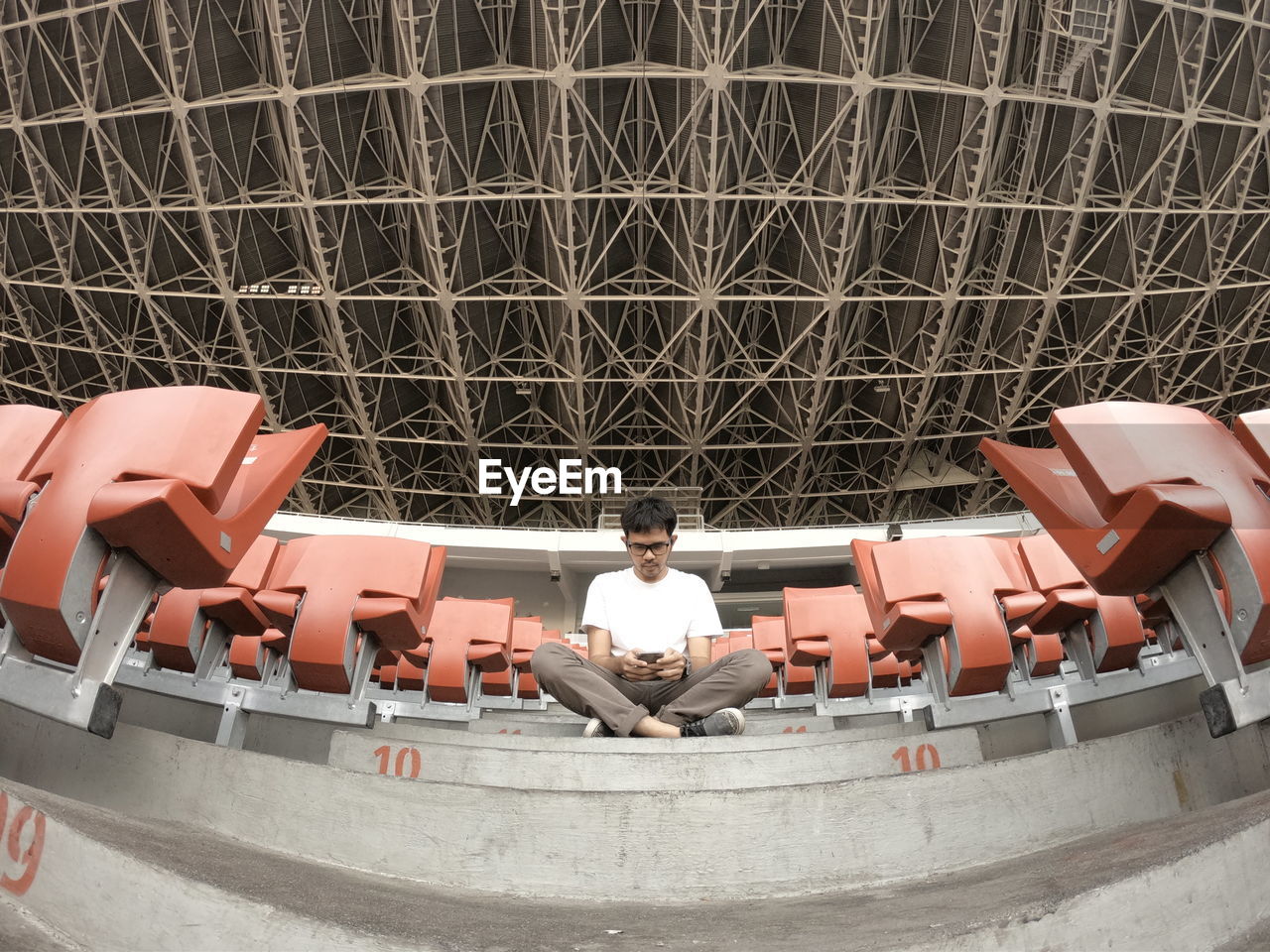 Digital composite image of man sitting in modern building