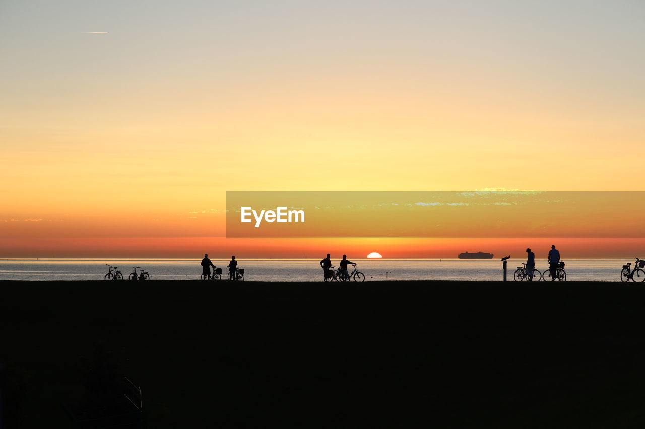 SILHOUETTE PEOPLE ON BEACH DURING SUNSET