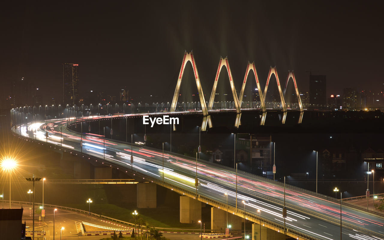 LIGHT TRAILS ON BRIDGE AT NIGHT