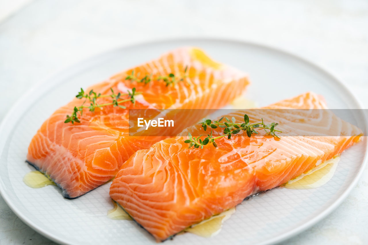 Fresh salmon fillet with herbs on a plate for delicious salmon steak.