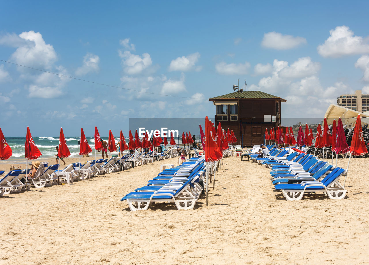 Side view of sun loungers in row on beach