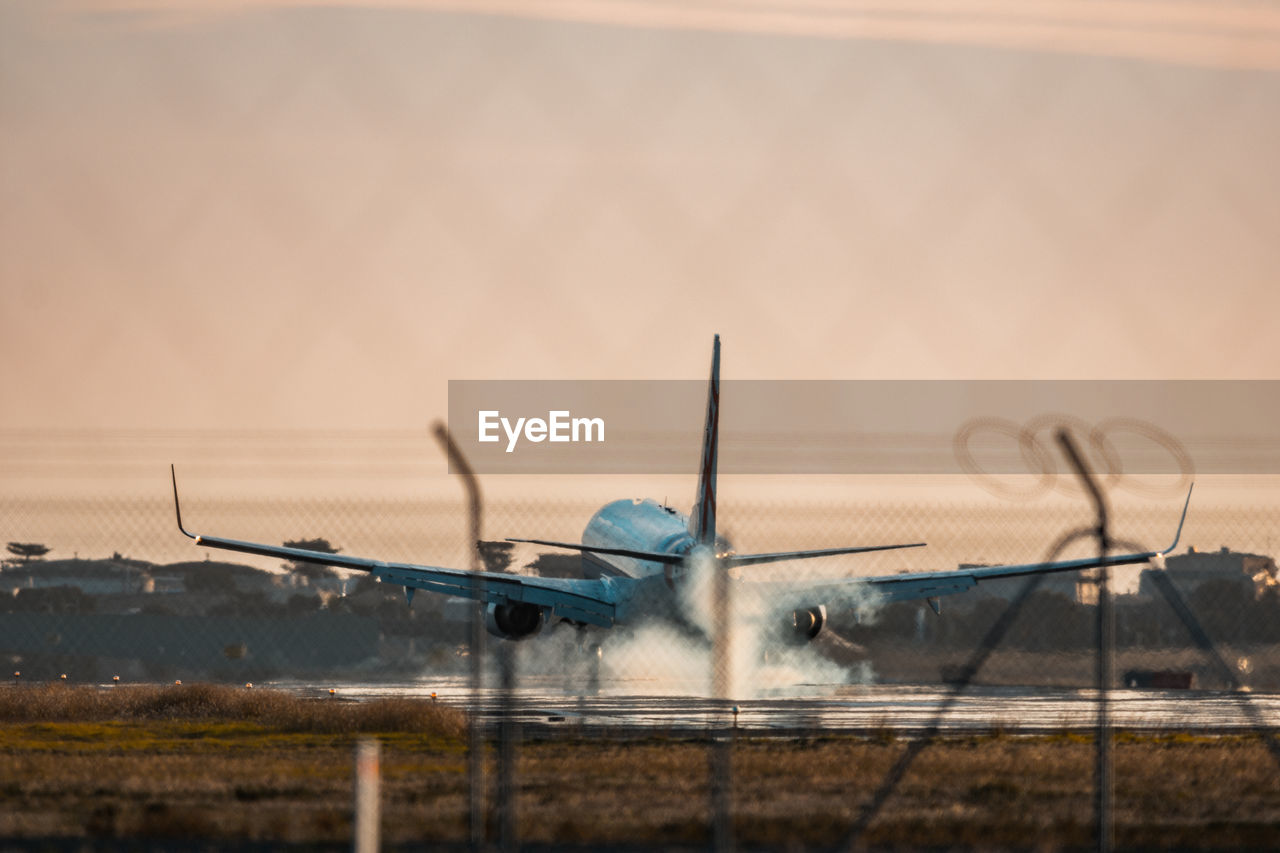 Close-up of airplane taking off against sky