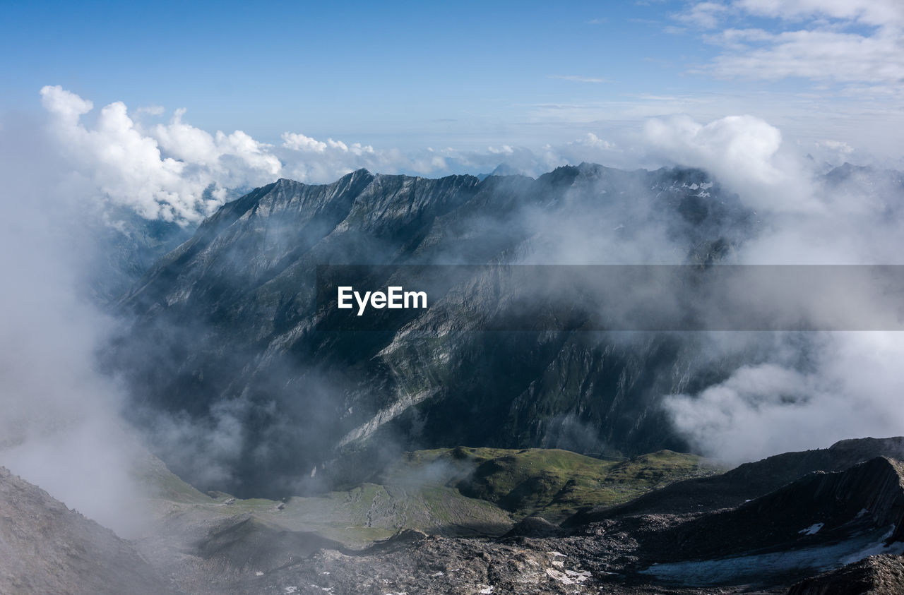 SCENIC VIEW OF CLOUDS OVER MOUNTAINS