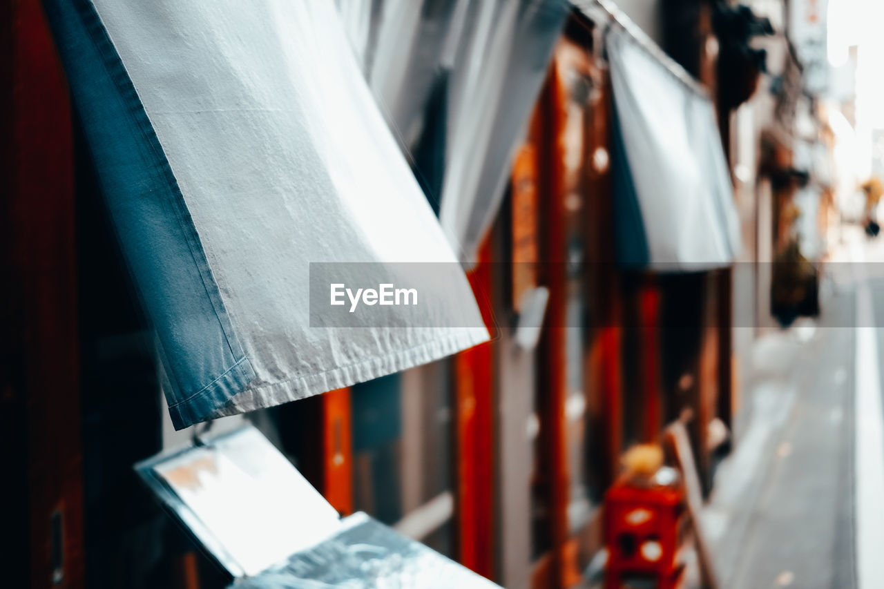 CLOSE-UP OF PAPER HANGING IN ROW