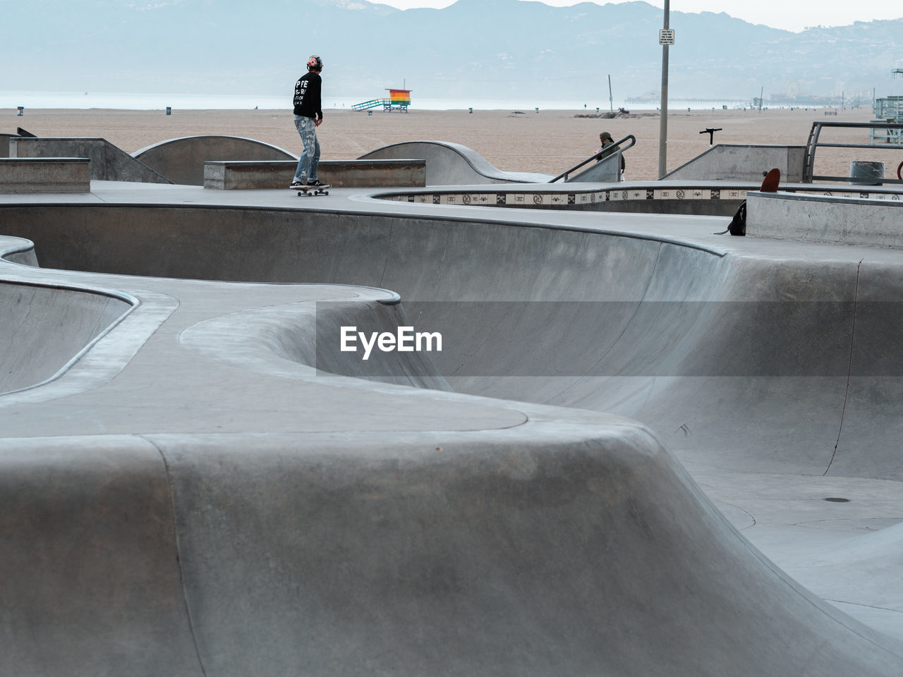 REAR VIEW OF MAN SKATEBOARDING ON SKATEBOARD