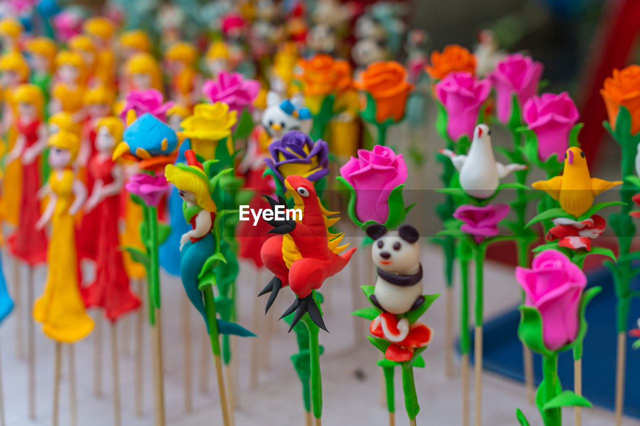 multi colored, flower, representation, no people, toy, animal representation, focus on foreground, large group of objects, flowering plant, close-up, creativity, celebration, decoration, variation, craft, in a row, retail, nature, figurine, outdoors, plant, pinwheel toy, day, abundance, vibrant color