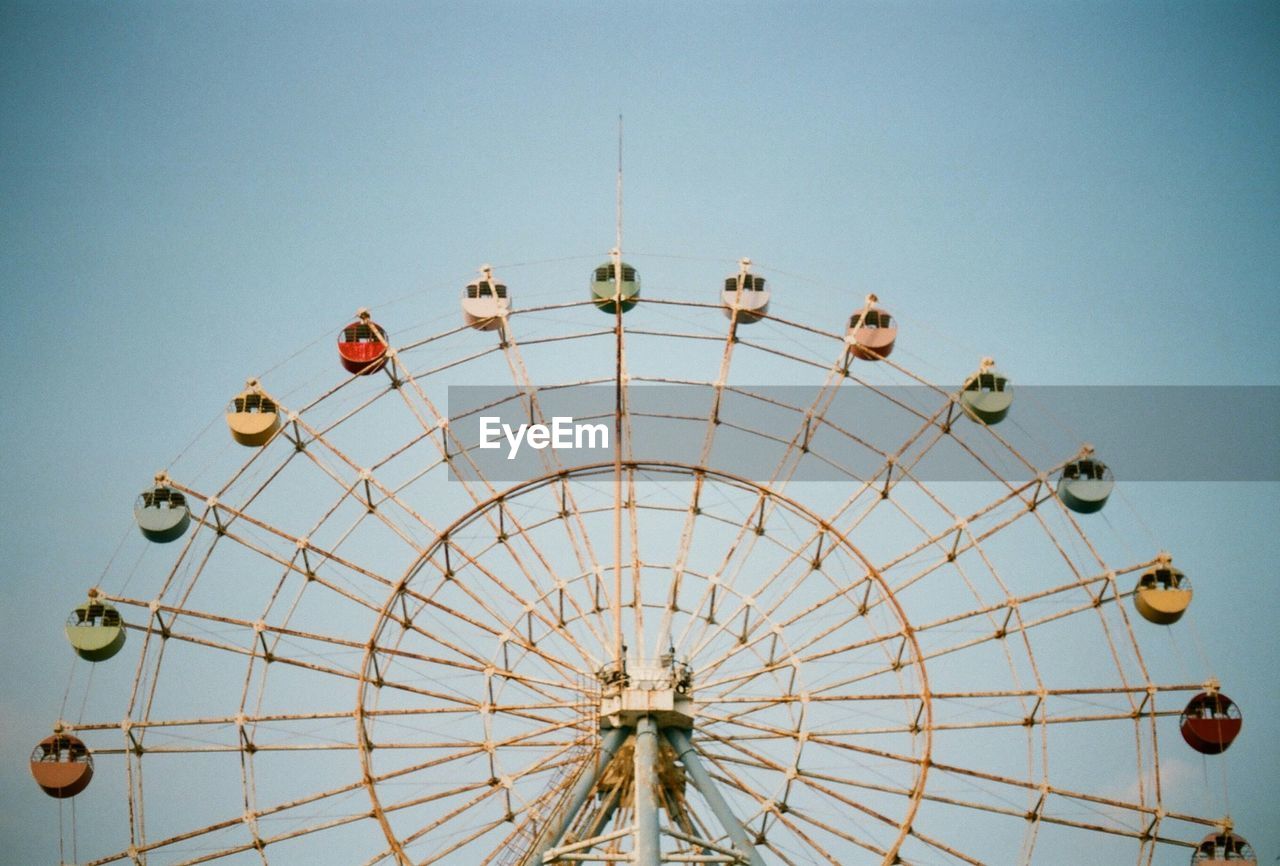 Low angle view of ferris wheel against clear sky