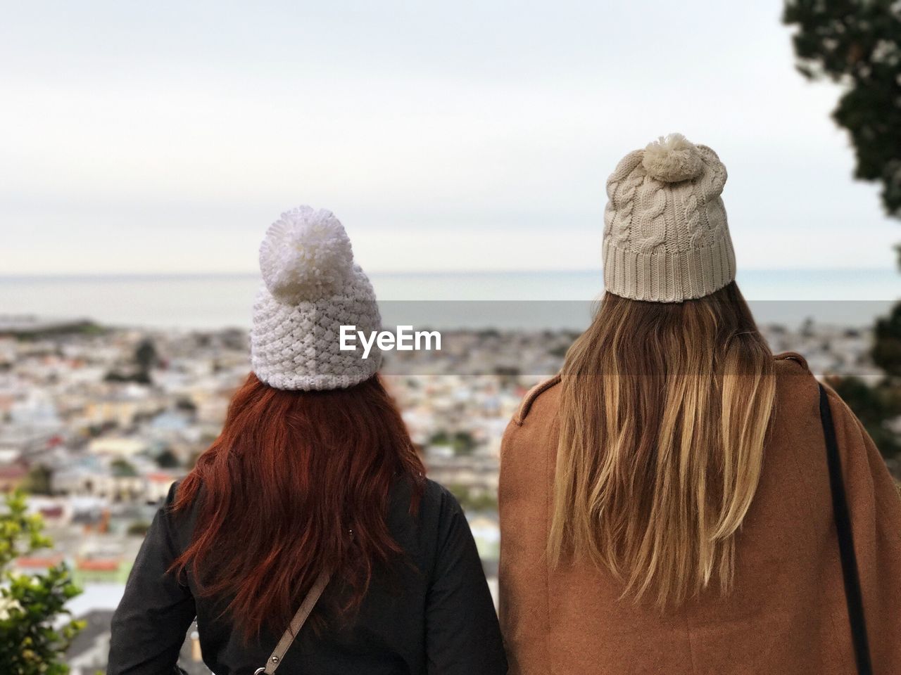 Rear view of female friends standing at beach