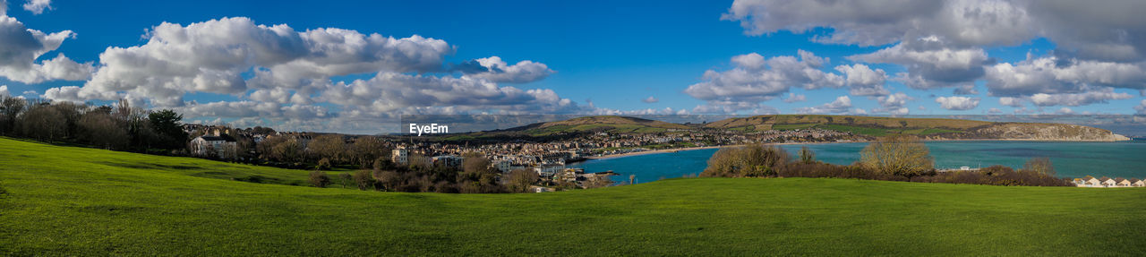 PANORAMIC VIEW OF GREEN LANDSCAPE AND TREES AGAINST SKY