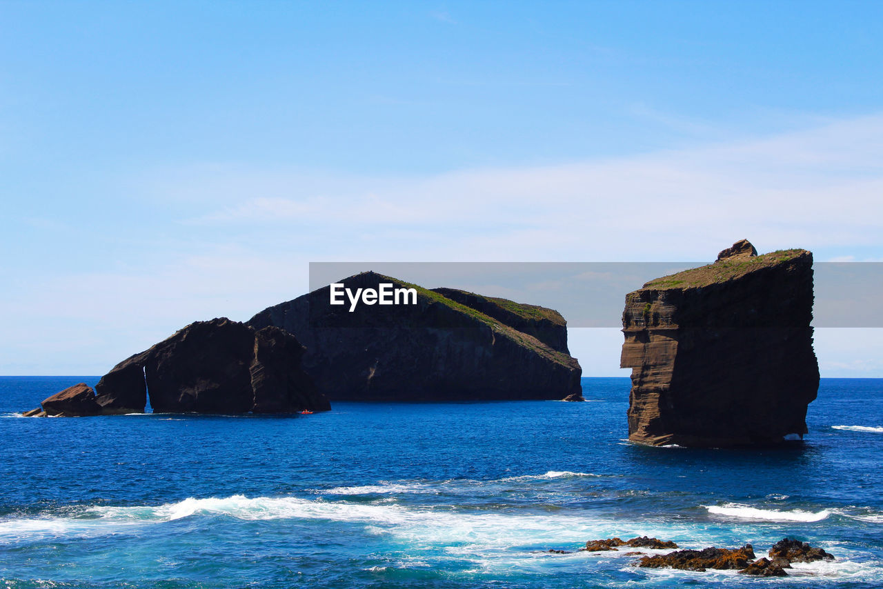 BUILT STRUCTURE ON ROCKS BY SEA AGAINST SKY