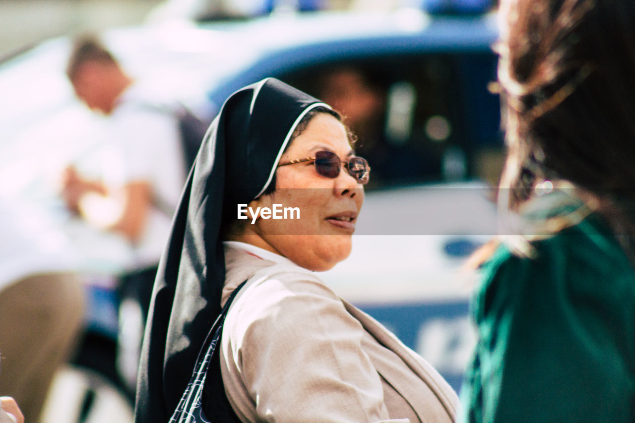 PORTRAIT OF SMILING WOMAN WEARING SUNGLASSES