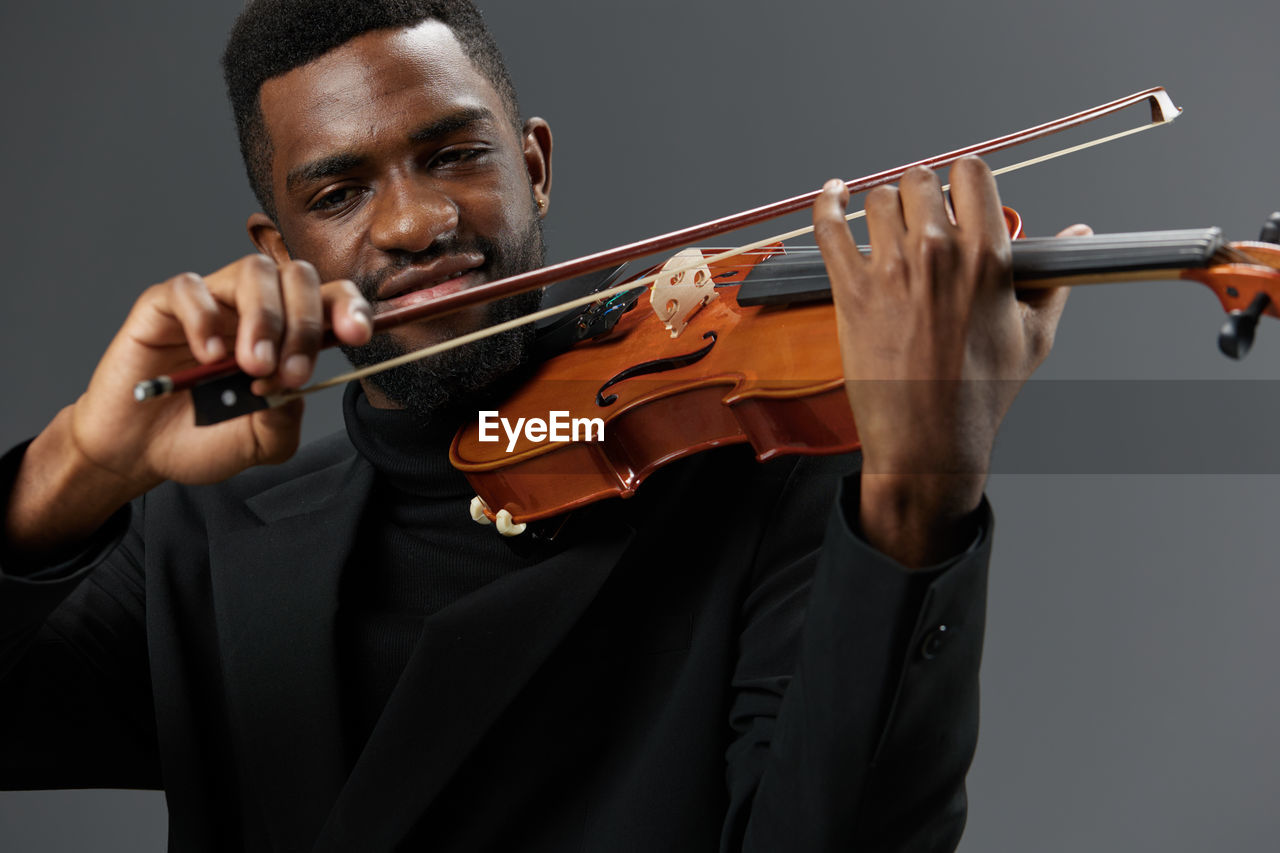 cropped hand of man playing violin