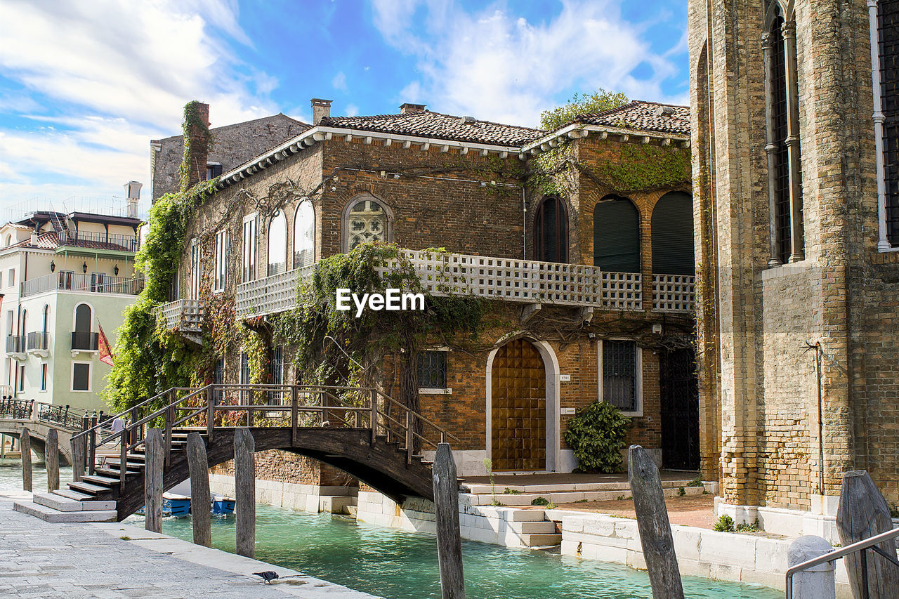 Arch bridge over canal against buildings in city