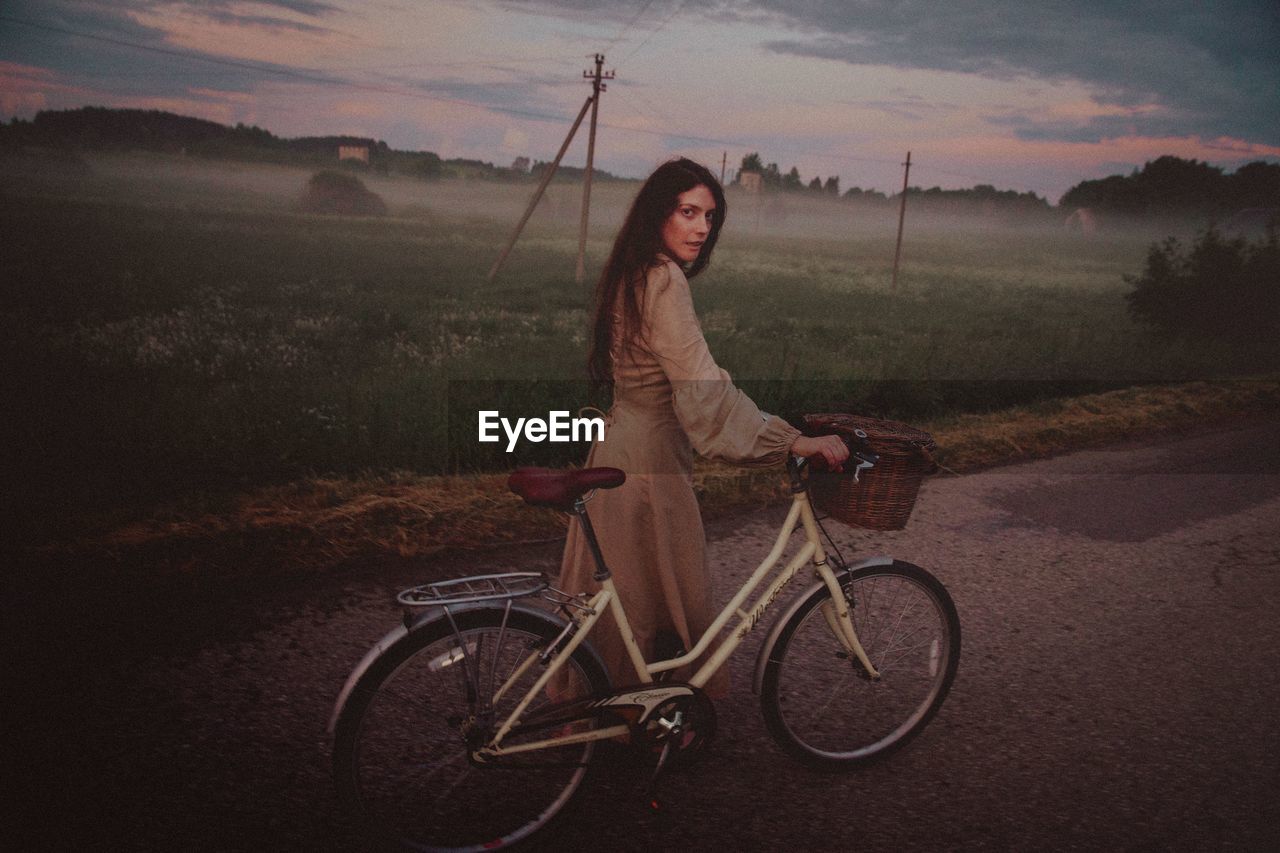 Young woman riding bicycle on road