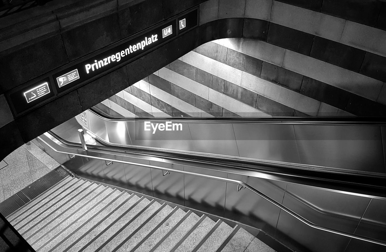 LOW ANGLE VIEW OF ESCALATOR IN ILLUMINATED SUBWAY STATION