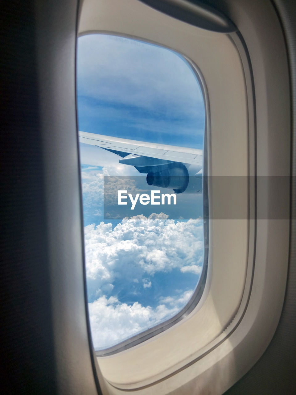 View of cloudy sky seen through an airplane window