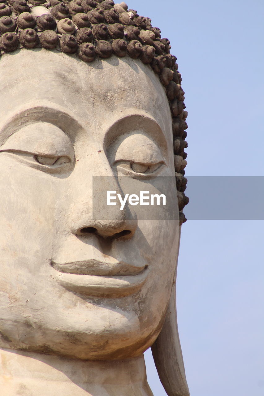 Low angle view of statue of buddha against clear sky