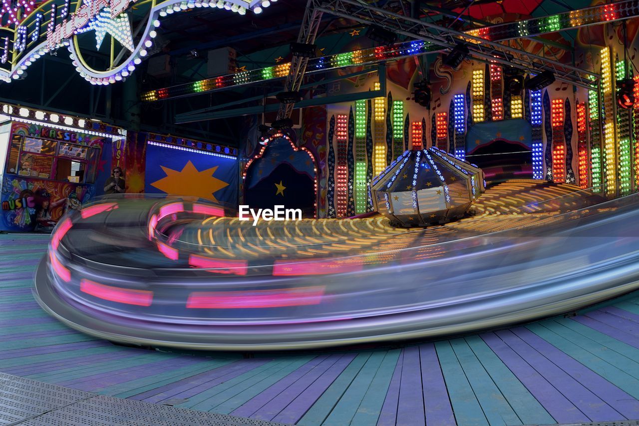 CLOSE-UP OF ILLUMINATED CAROUSEL AT NIGHT