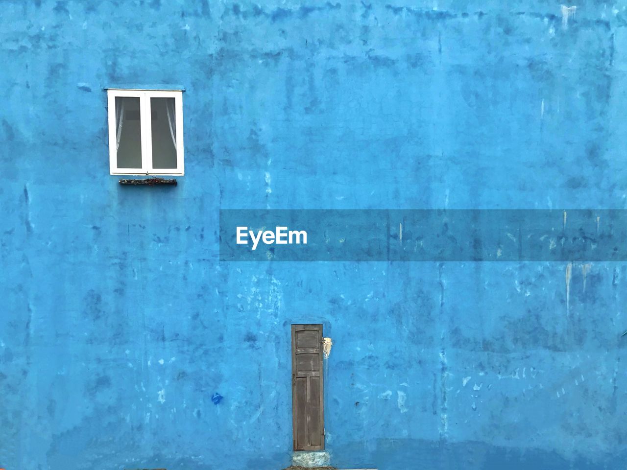 Closed window on blue wall