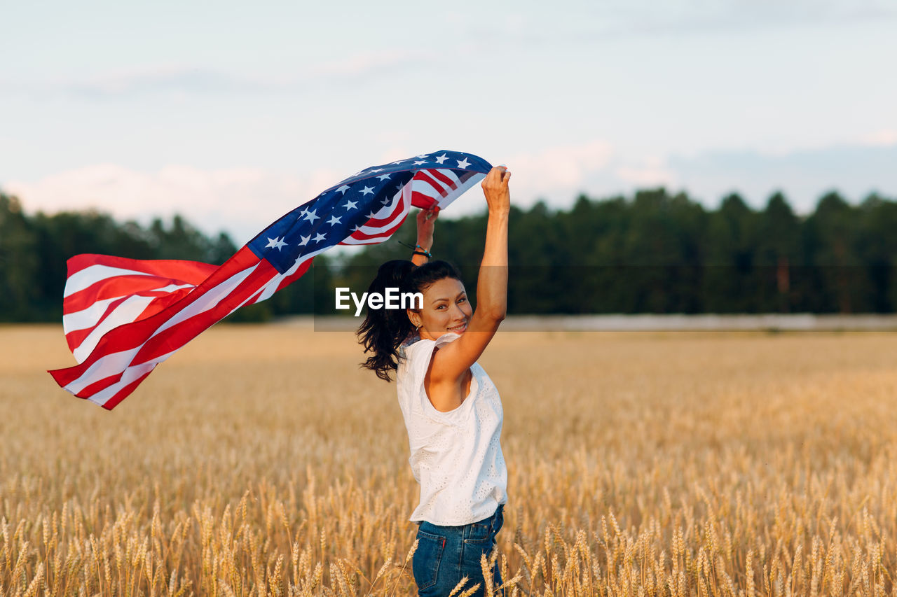 HAPPY WOMAN STANDING ON FIELD