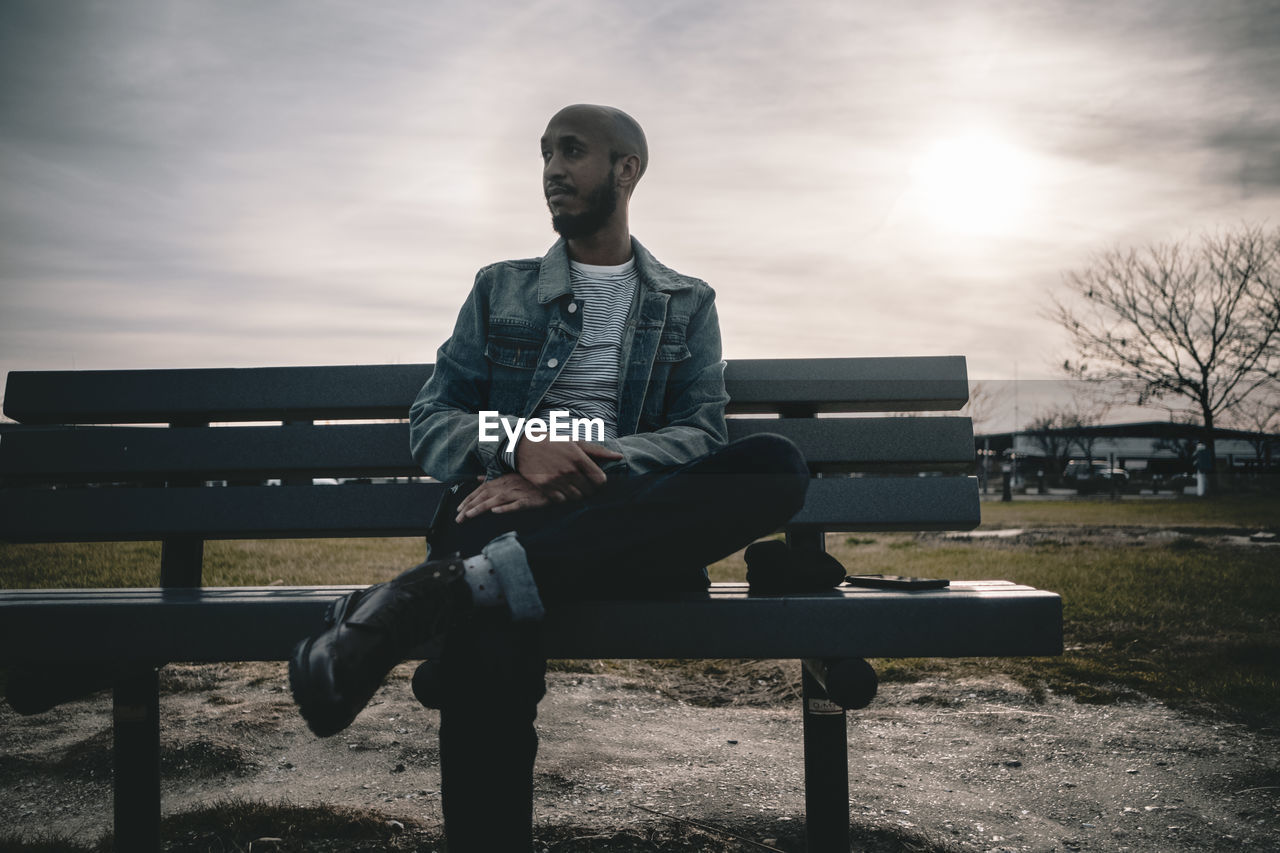 Full length of young man sitting on bench