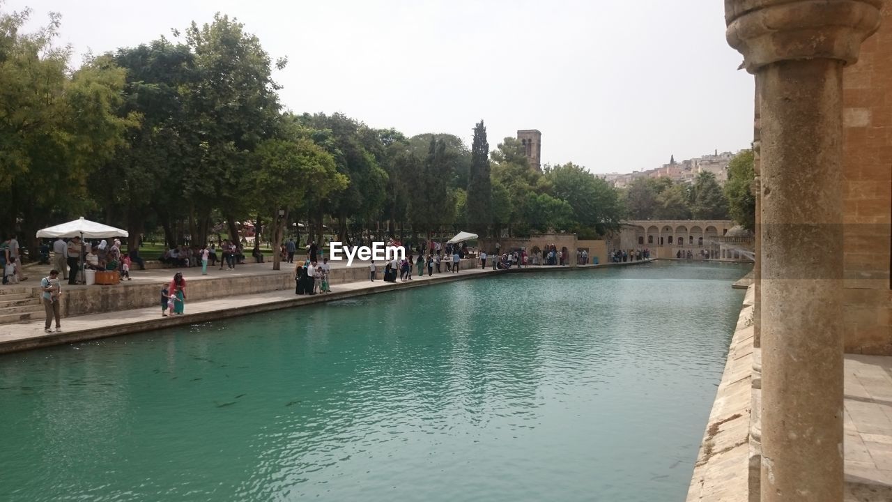 PEOPLE IN WATER AGAINST CLEAR SKY