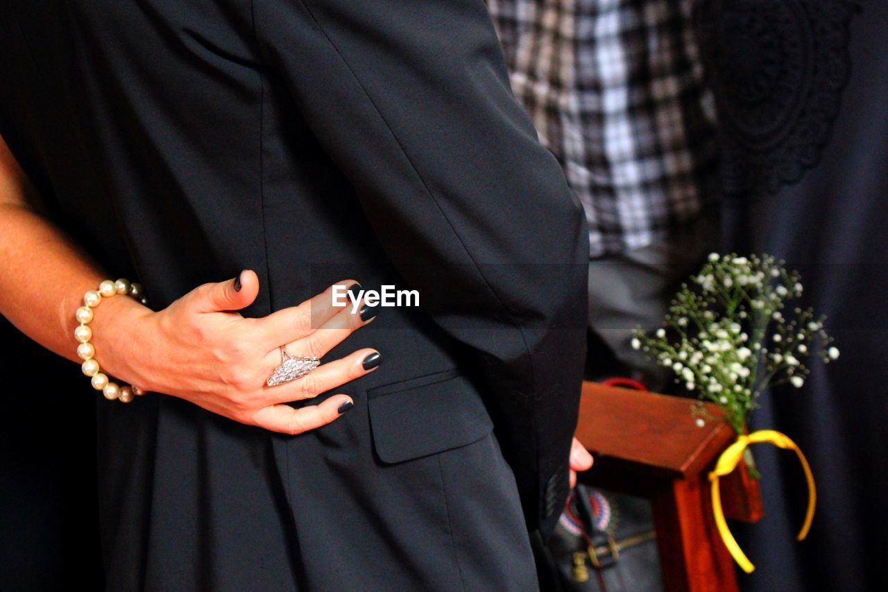 Cropped image of couple and man standing at church during wedding ceremony