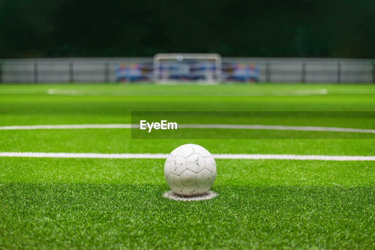 sports, grass, soccer, team sport, ball, green, soccer-specific stadium, plant, sports equipment, soccer ball, soccer field, playing field, lawn, player, kicking, no people, baseball field, stadium, sport venue, nature, focus on foreground, competition, day, outdoors, football, close-up, activity