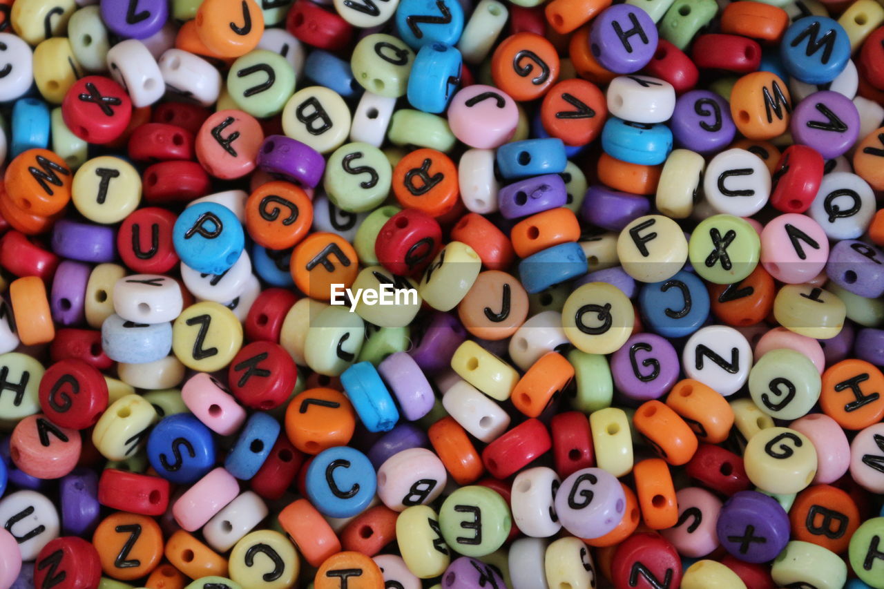 Full frame shot of multi colored beads with alphabets