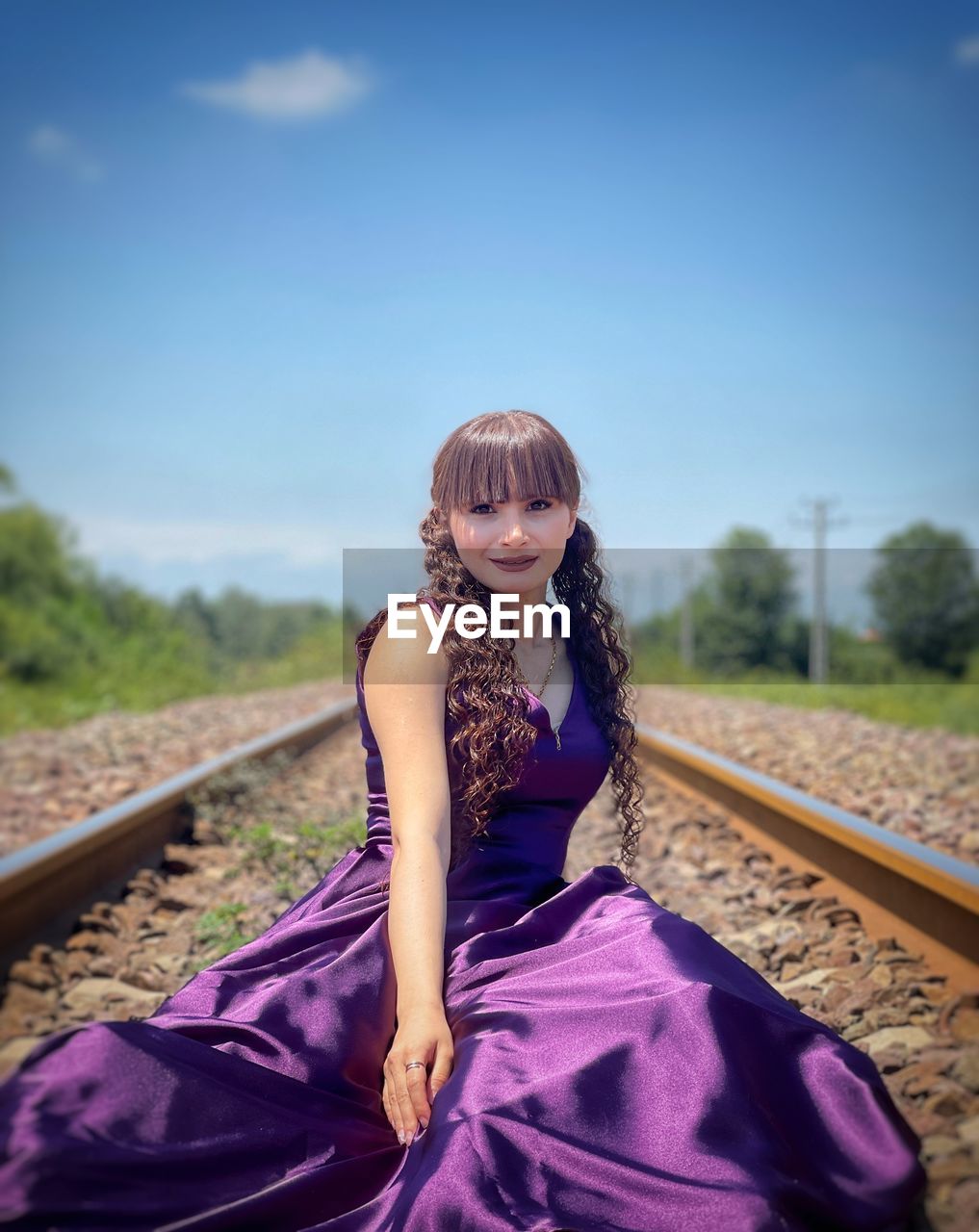 Portrait of young woman standing against sky