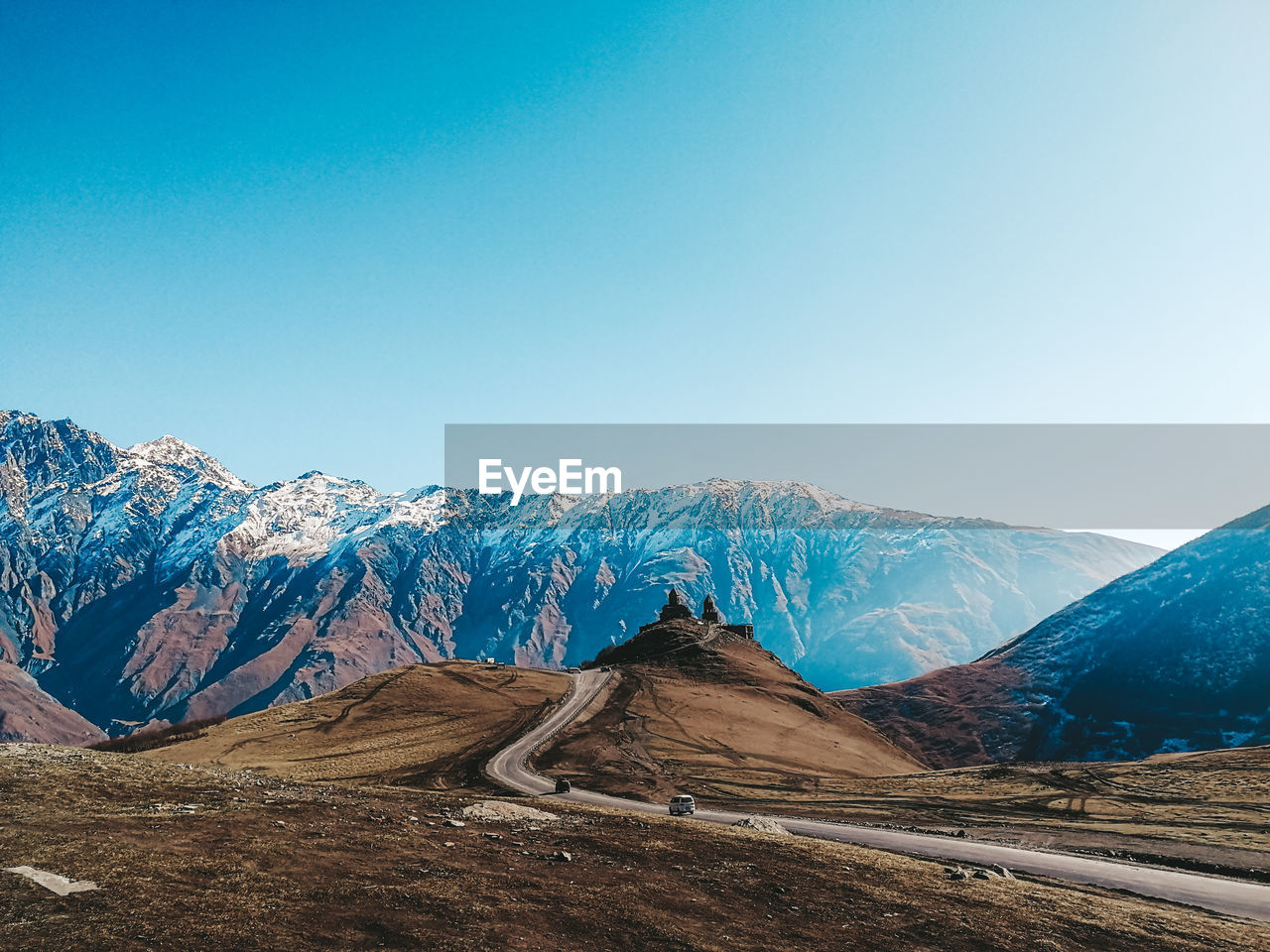 Scenic view of snowcapped mountains against clear blue sky