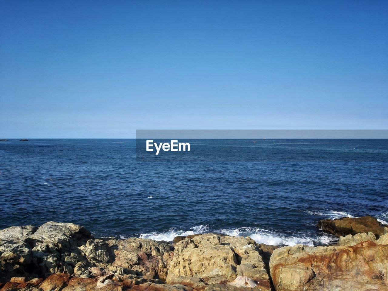 Scenic view of sea against clear blue sky