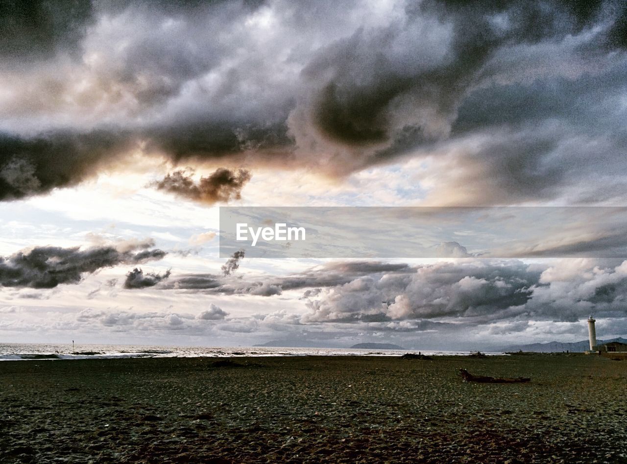 VIEW OF BEACH AGAINST CLOUDY SKY