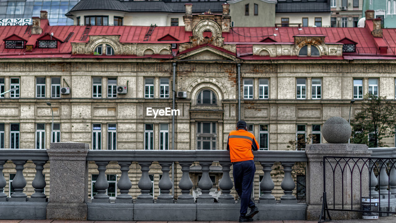 Rear view of man standing against building