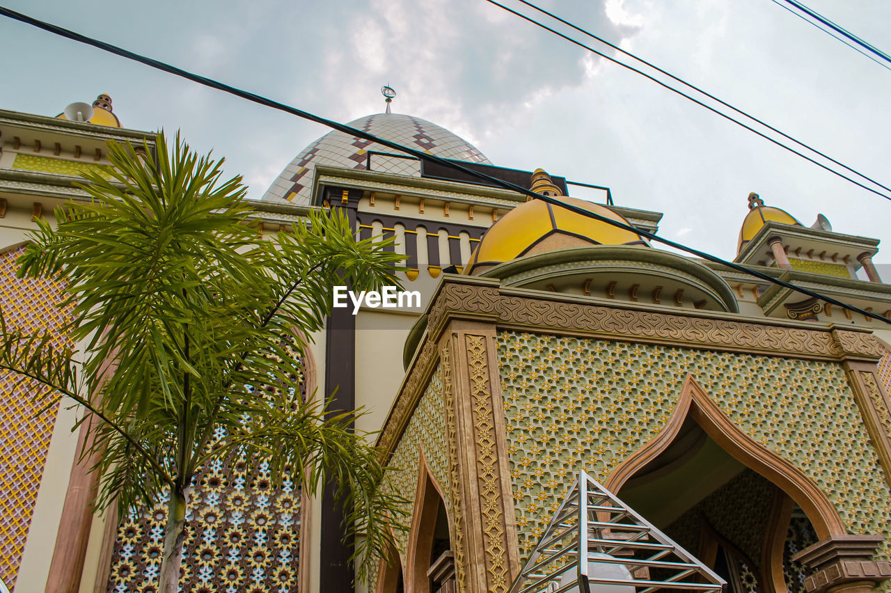 Low angle view photo of the mosque's dome in gold,and wrapped in cotton clouds