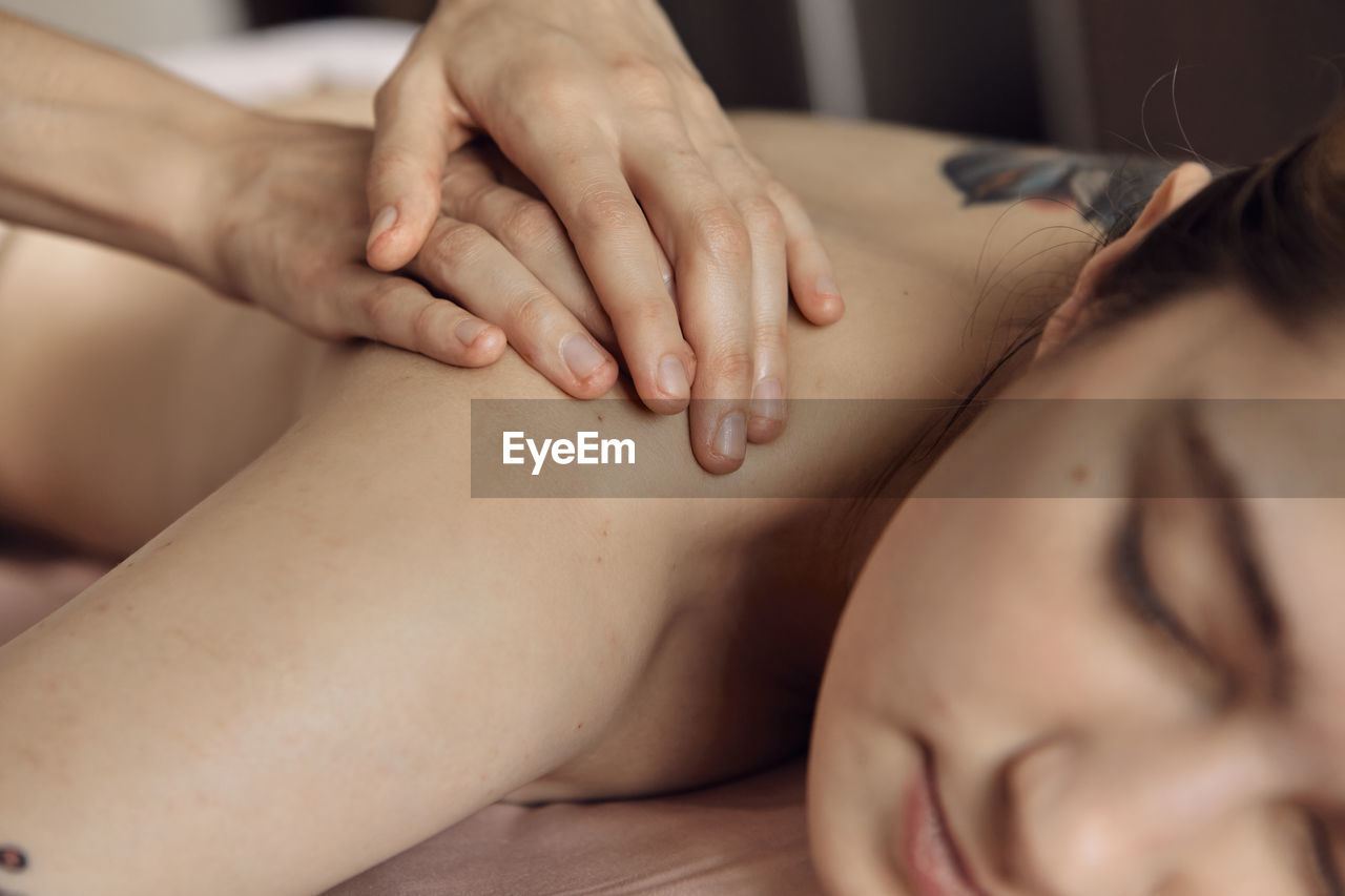 Cropped image of woman massaging customer