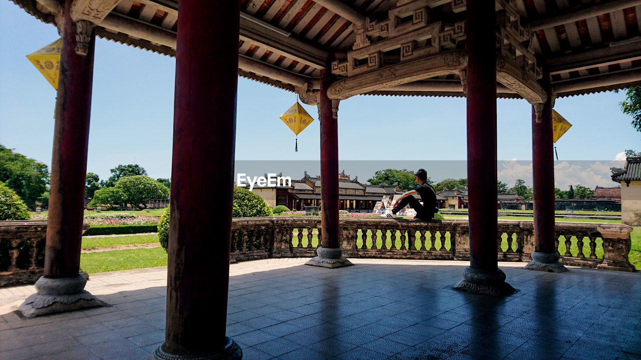 Side view of man sitting on railing