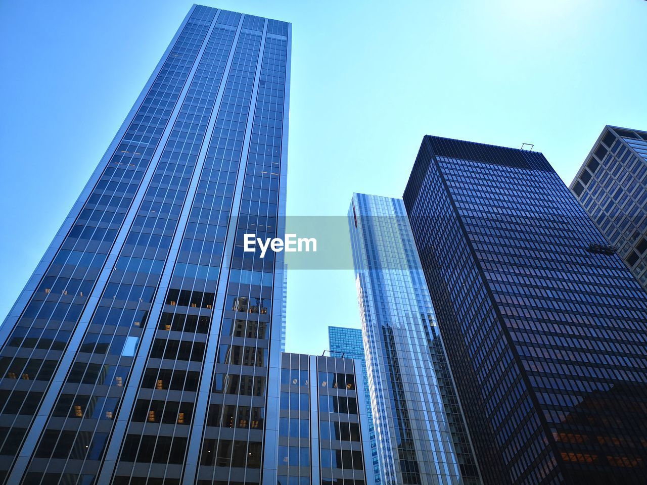 Low angle view of modern buildings against clear blue sky