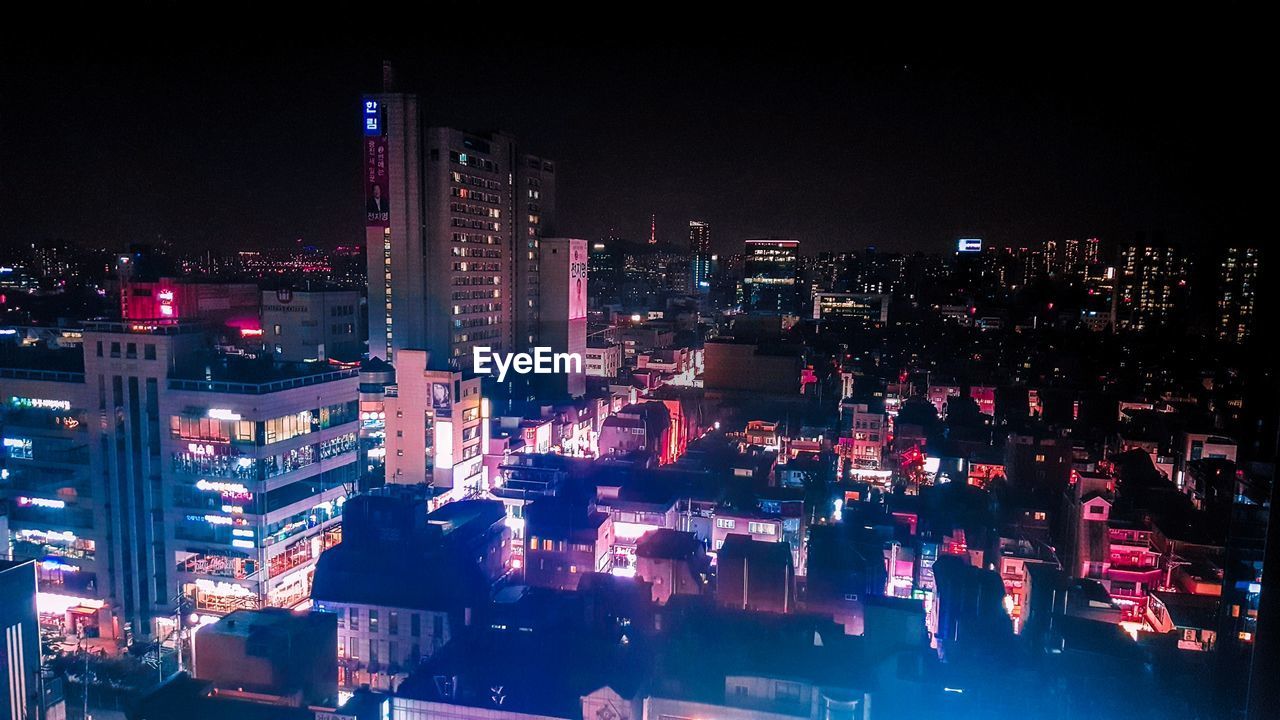 ILLUMINATED BUILDINGS IN CITY AT NIGHT