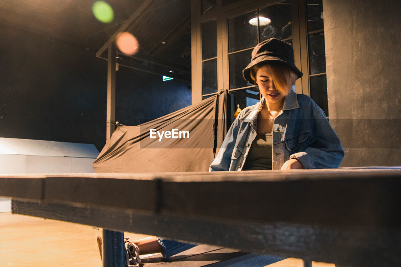 Young woman looking down while sitting at table