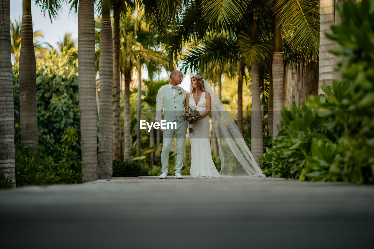 Wedding couple walking on palm trees