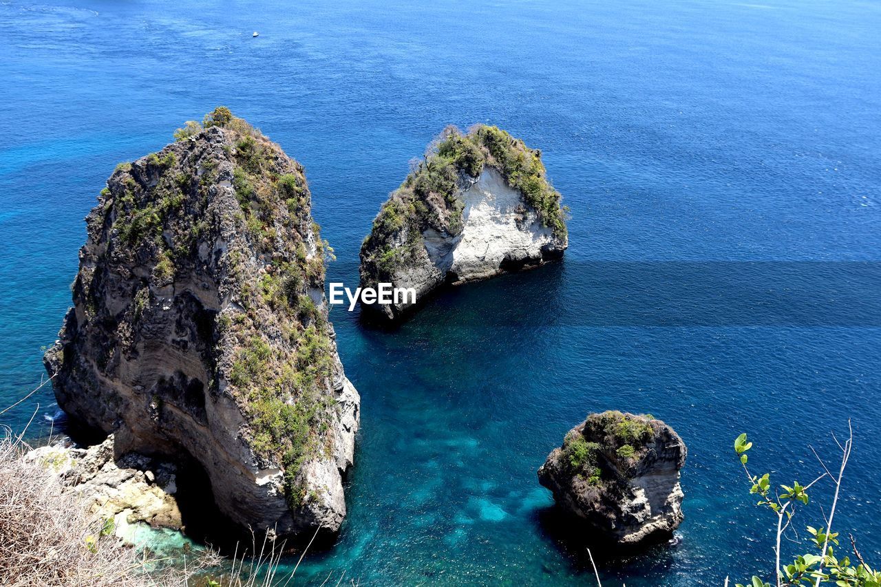 HIGH ANGLE VIEW OF ROCKS ON SEA