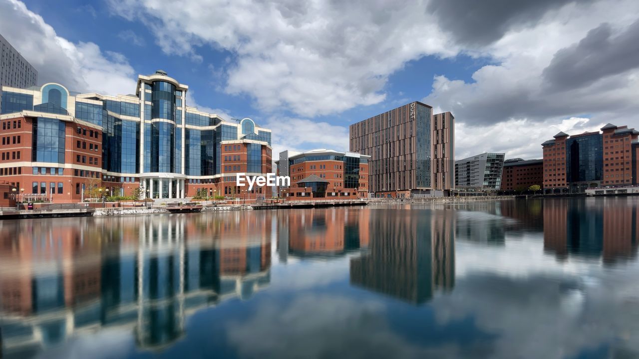 REFLECTION OF BUILDINGS IN CITY AGAINST SKY