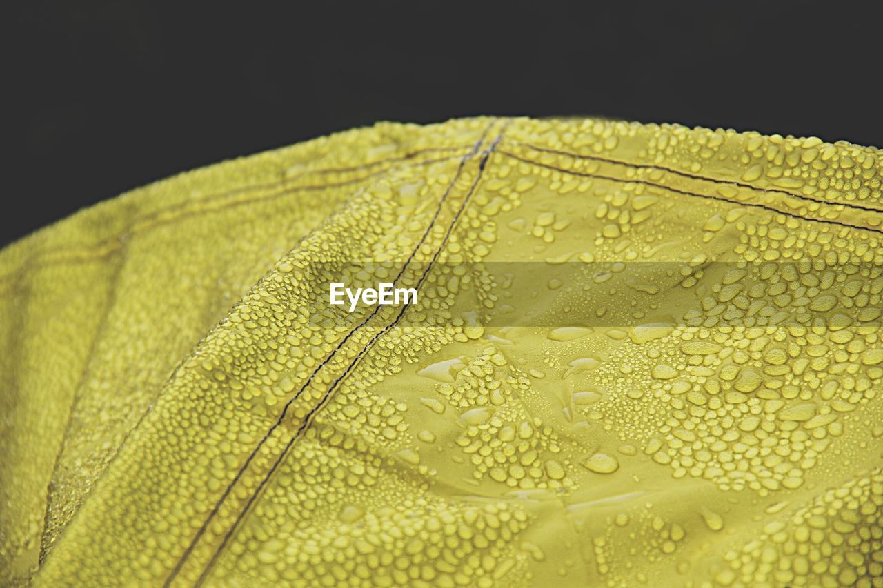 Close-up of yellow fabric with raindrops