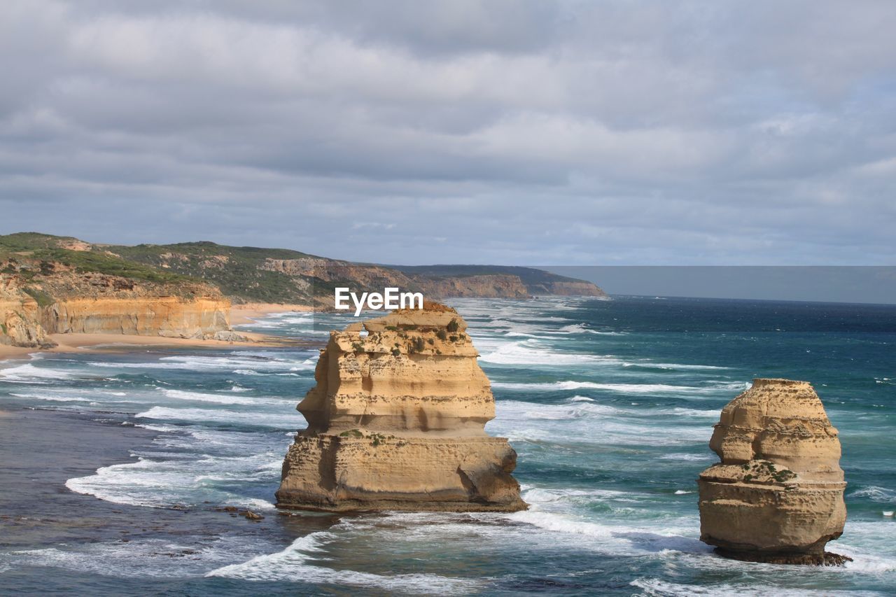 Rock formation on sea shore against sky