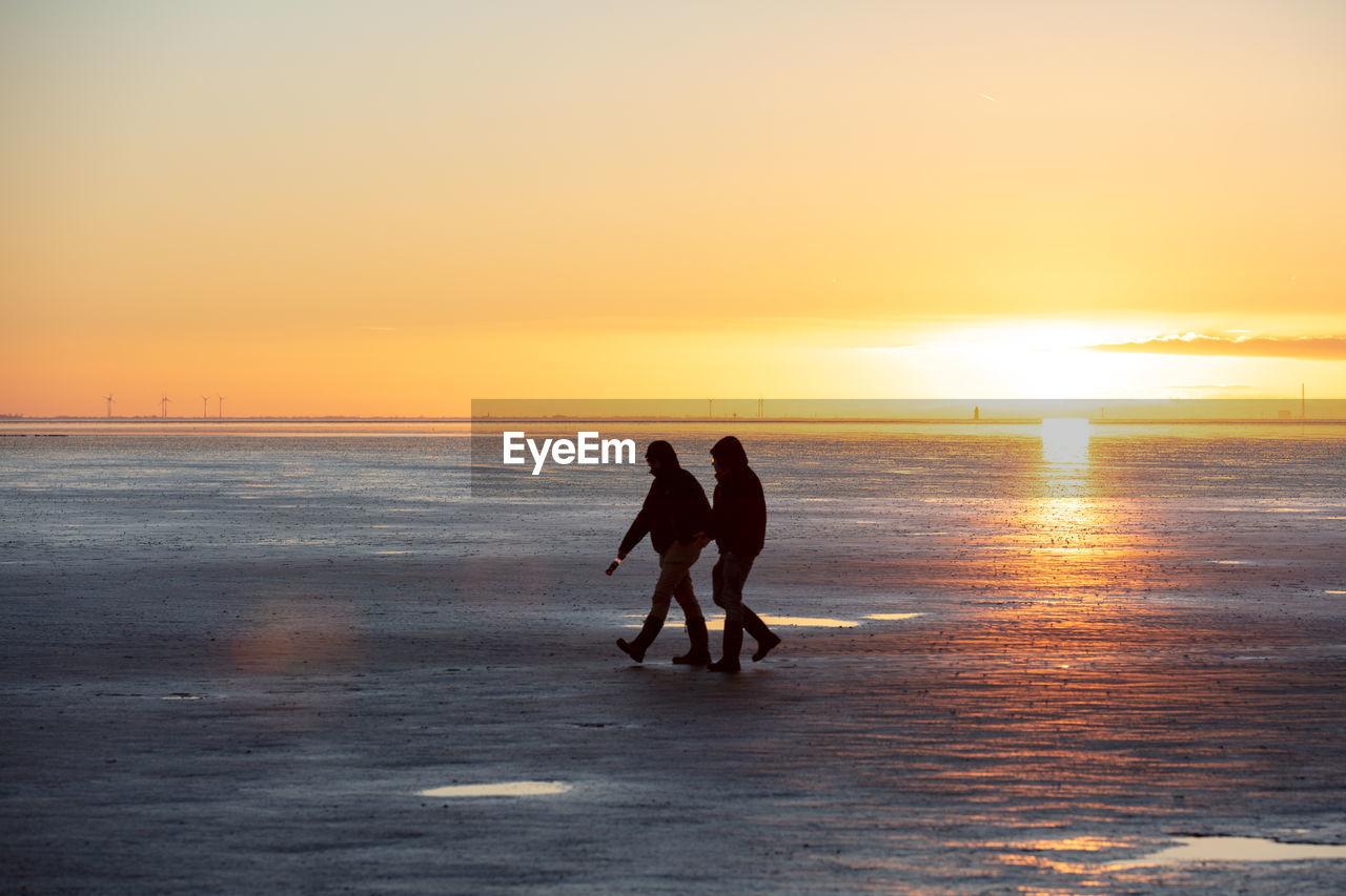 SILHOUETTE MEN ON BEACH DURING SUNSET