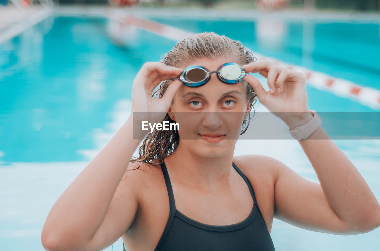 Portrait of smiling young woman in swimming in pool