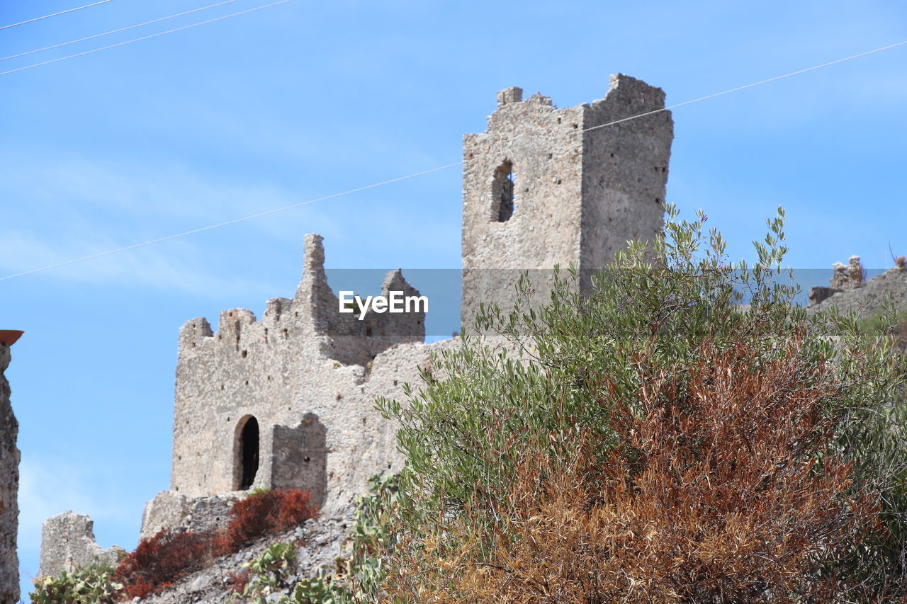 architecture, history, built structure, the past, sky, building exterior, building, castle, nature, travel destinations, old, fort, medieval, plant, travel, blue, no people, low angle view, wall, tower, ancient, day, tourism, fortified wall, clear sky, château, outdoors, stone material, tree, old ruin, religion, ruins, fortification, land, place of worship, cloud, house, wall - building feature