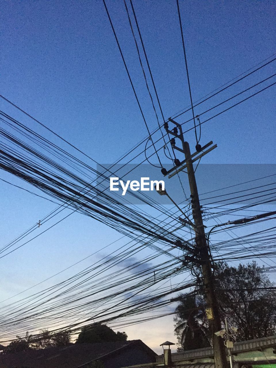 LOW ANGLE VIEW OF ELECTRICITY PYLONS AGAINST CLEAR BLUE SKY